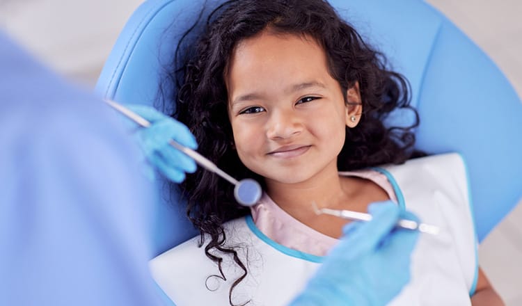 little girl in dentist chair smiling