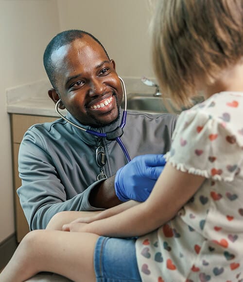Provider portrait Perry J. Leonard Jr., MD, MSPH, MHS performs an exam with young patient