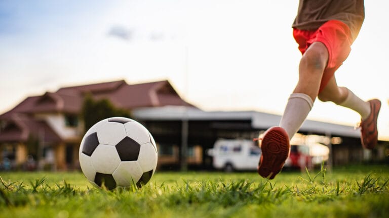 Kid playing soccer in a field