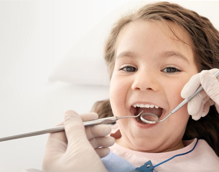 Toddler girl smiling at the dentist office