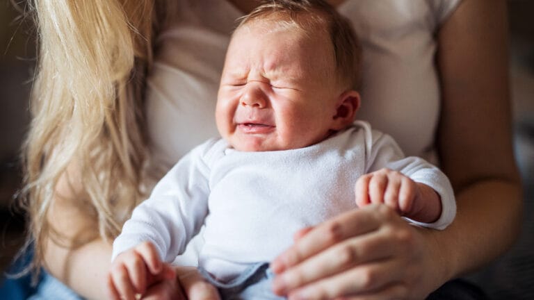 Newborn crying in mother's lap