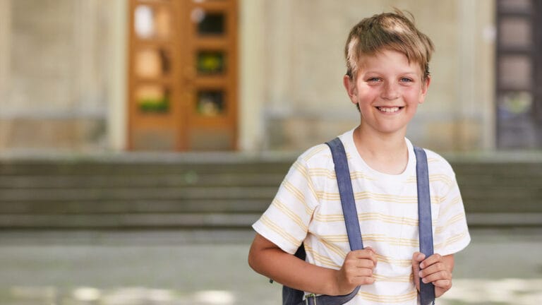 Young pre-teen standing outside for his first day of school