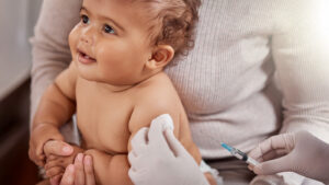 Young baby getting a vaccine shot by a pediatrician
