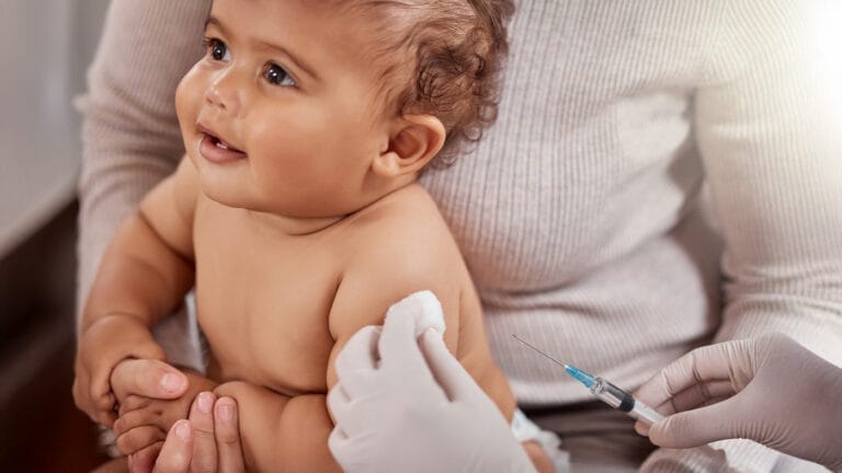 Young baby getting a vaccine shot by a pediatrician
