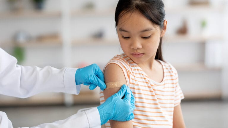 Little girl getting a vaccine and a band-aid put over