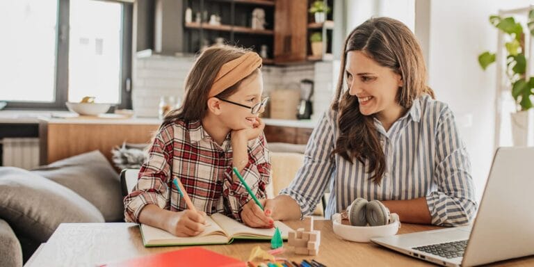 Mother and child smiling while doing homework