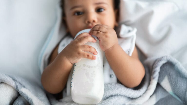 Baby drinking breast milk from bottle