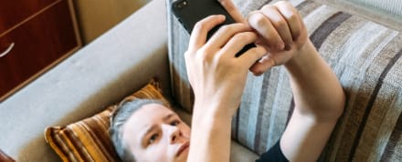 Teen boy using a mobile phone on the couch