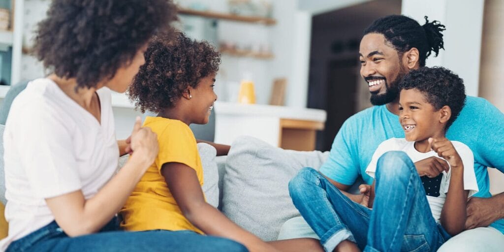 Parents and their sons smiling in the living room