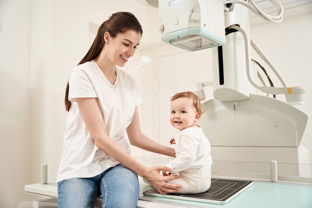 Happy toddler with her mother at the x-ray machine