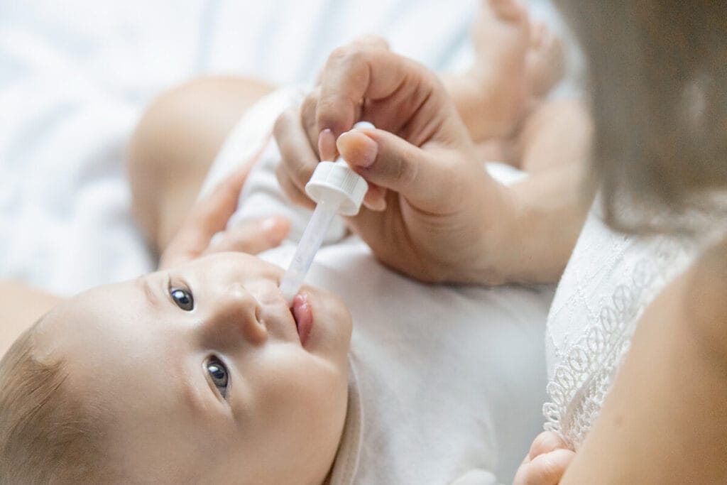 Infant receives medication via dropper