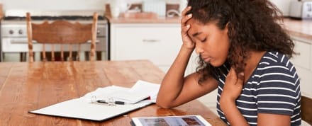 Teen girl doing homework at the kitchen table