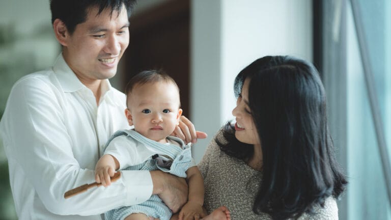 Young parents holding their baby together