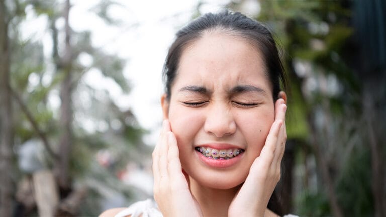 Young girl grimacing from broken bracket in her braces