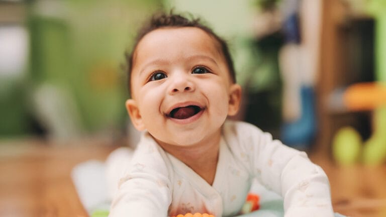 Young happy baby crawling on floor