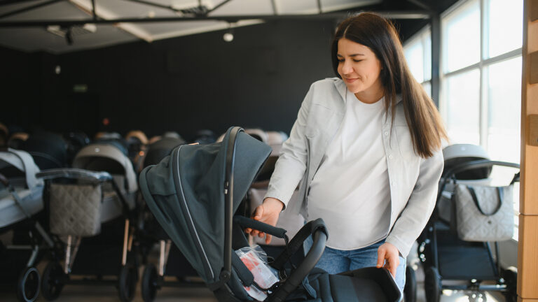 Young pregnant mom shopping for strollers
