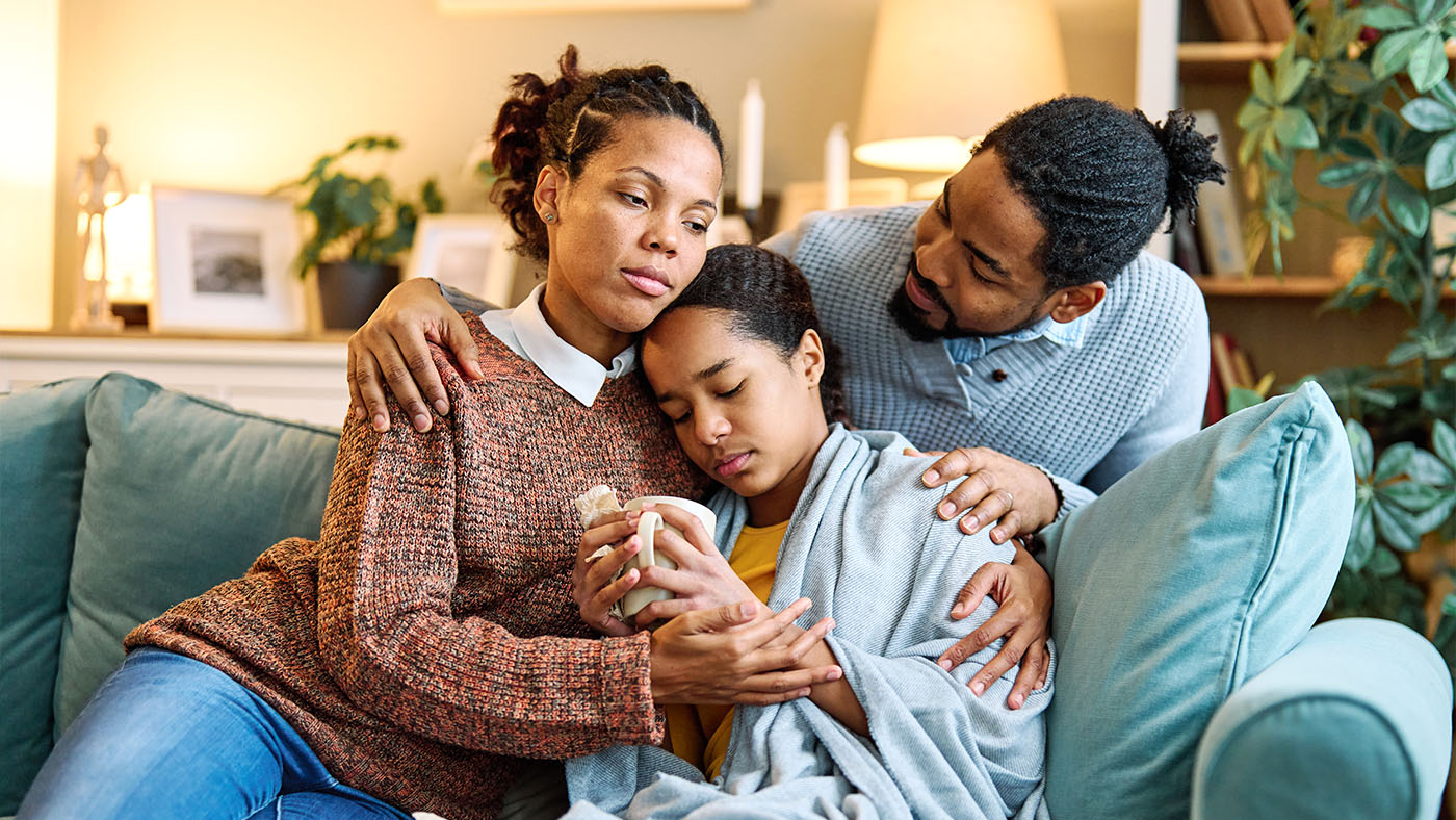 Parents consoling teenager on the couch
