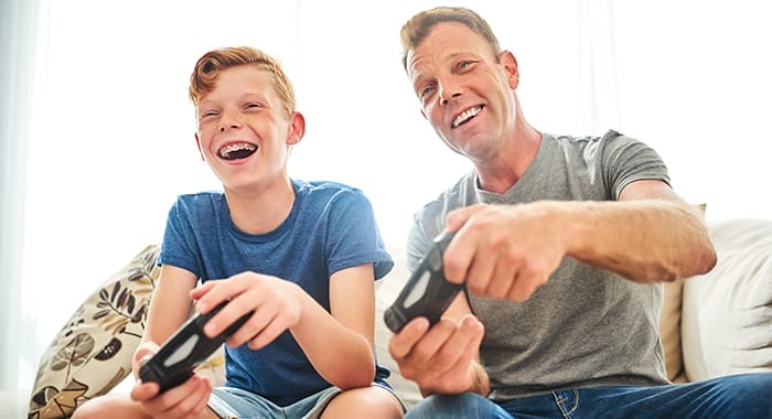 Father and son smile while gaming
