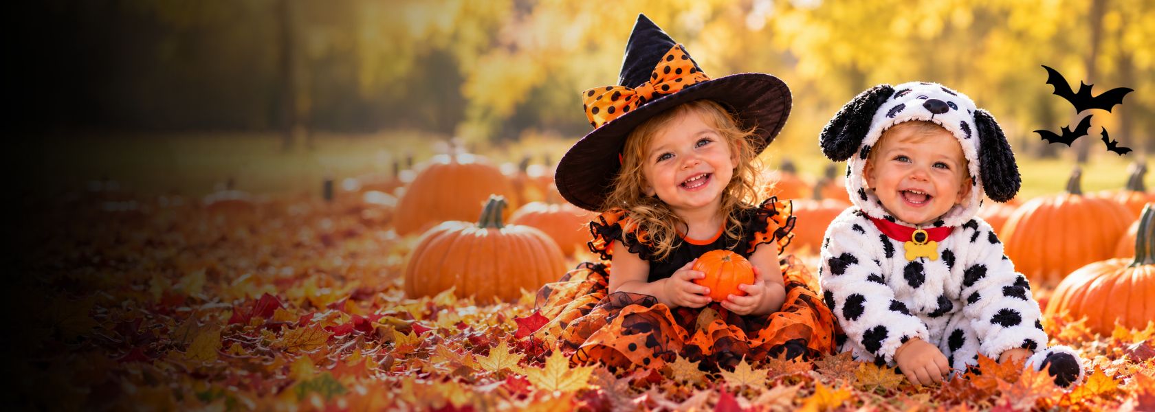 two young kids in Halloween costumes in pumpkin patch