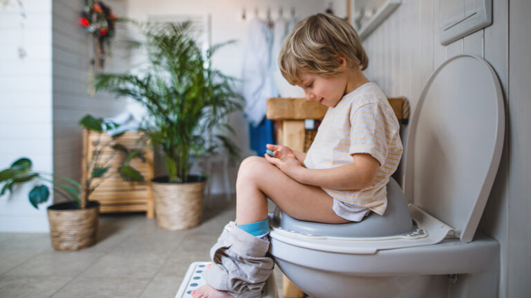 Young boy on potty with phone